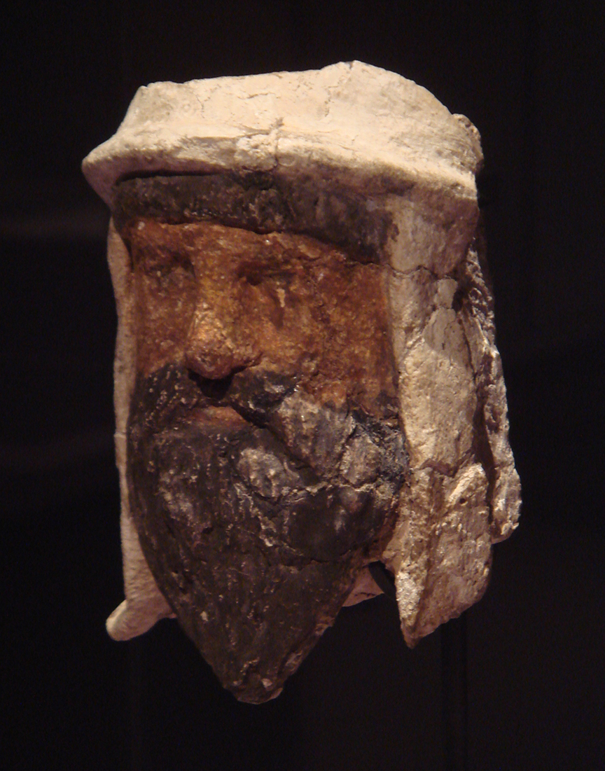 PLATE III. Painted unbaked clay head of a bearded man wearing a bašlyk, Temple of the Oxus, Takht-i Sangin, Corridor 2, Deposit 4, Height: 10.5 cm, 3rd-2nd century BCE. National Museum of Tajikistan, Inv. Nr. M 7258. Photograph by ALFGRN, licensed under CC BY-SA 2.0 (https://www.flickr.com/photos/156915032@N07/51657103231/).